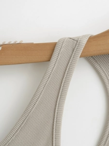 Close-up of premium rib-knit fabric texture and shoulder strap on a wooden hanger