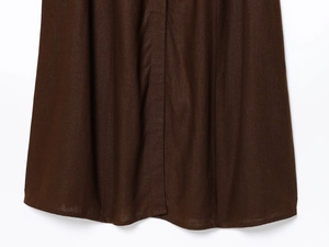 Detailed close-up of dark brown linen midi skirt hem showing natural woven texture and stitching