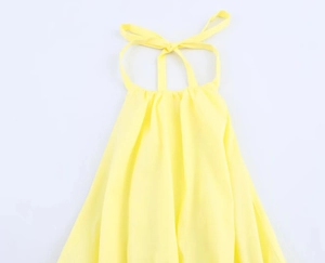Detail of a bright yellow halter neck dress with delicate drawstring pleats at the neckline