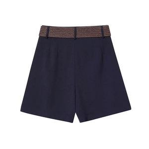 Detail of high-waist A-line navy shorts featuring a brown woven belt and pleated waist design
