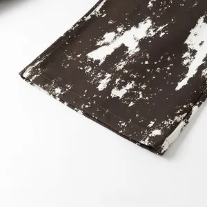 Dettaglio del tessuto twill marrone scuro con stampa a spruzzi bianchi e cuciture rifinite