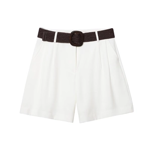 Detail of high-waist white shorts with dark brown woven belt and pleated design