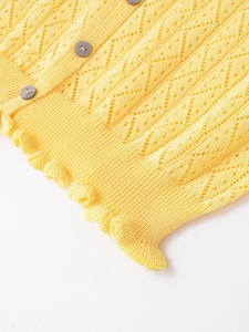 Détails d'un caraco en maille jaune avec points ajourés et ourlet à volants féminin