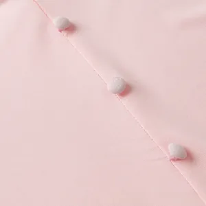Détail de la robe en tricot rose montrant la texture sergée et les boutons assortis