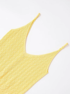 Détail de la texture en maille jaune vif et du motif ajouré en losange sur le caraco