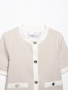 Detailed close-up of textured linen blend short sleeve top with silver buttons