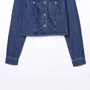 Fashionable dark blue denim short jacket for women featuring white contrast buttons