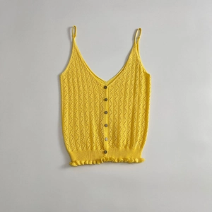 Camisole tricotée jaune pour femme avec col V, boutons et ourlet volanté sur fond gris