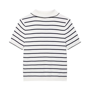 Detail of knitted top showing high neck with black scalloped trim and striped texture