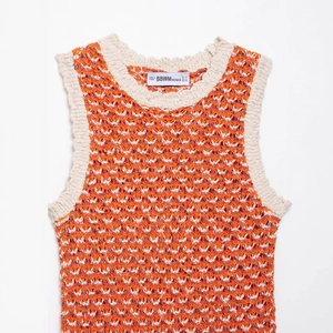 Textured orange and white knit mini dress featuring wavy patterns and ribbed trim finish
