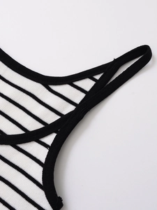 Macro shot of striped knit top showing black and white texture with neat hem finish