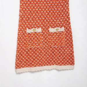 Textured orange and white knit mini dress with wave patterns and golden crest buttons