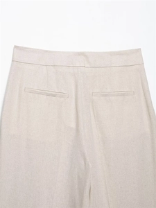 Detailed view of linen blend wide-leg trousers featuring rear welt pockets and beige texture
