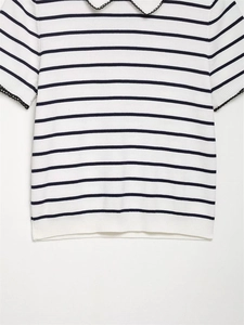 Detail of white and blue striped knit top with black scalloped embroidery on Peter Pan collar