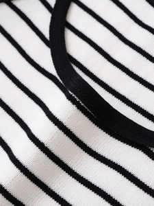 Close-up of classic black and white striped knit texture and round neckline piping