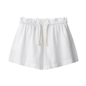 Dettaglio degli shorts bianchi in misto lino con vita elastica a balze e cordino intrecciato