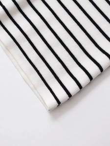 Close-up of premium black and white striped knit fabric showing fine texture and hem detail