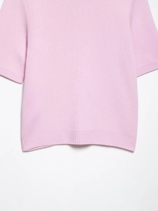 Vue détaillée du haut en tricot rose clair avec poignets côtelés et maille fine