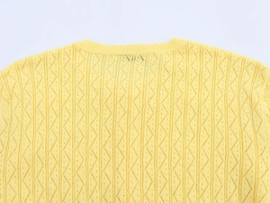 Detailed macro view of yellow hollow-out knit fabric with diamond geometric texture