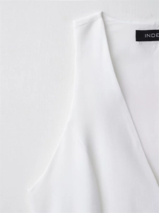 Detail of a white V-neck mini dress showing clean fabric texture and brand collar label