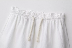 Dettaglio degli shorts in lino bianco con vita elasticizzata paperbag e coulisse