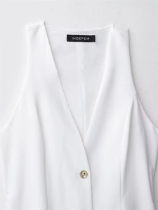 Detail of V-neck sleeveless top with premium fabric texture and gold metal button