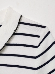 Close-up of white lapel with black scalloped lace trim on striped ribbed knit top