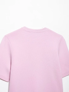 Gros plan sur la maille fine et le col côtelé de ce pull à manches courtes rose clair