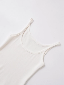 Close-up of white ribbed knit fabric texture and thin straps on a minimalist vest