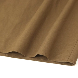 Detailed close-up of dark brown linen blend fabric showing neat hem stitching and texture