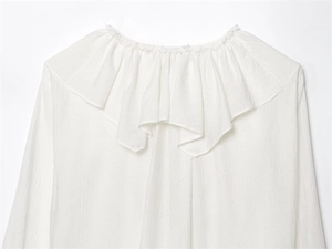 Detailed macro view of white layered ruffled collar and textured crinkle cotton fabric