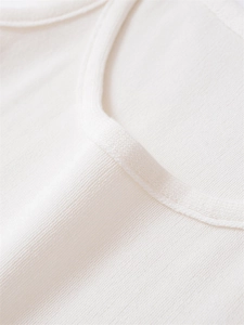 Close-up of ivory knit tank top neckline showing fine rib texture and quality piping