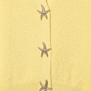 Robe en maille jaune pâle ornée de boutons métalliques en forme d'étoile de mer