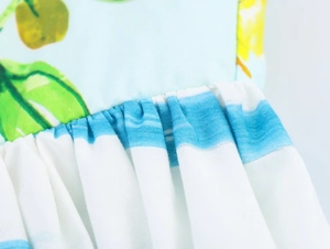 Close-up of lemon floral print and striped poplin fabric with pleated stitching detail