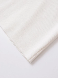 Close-up of the white ribbed knit fabric texture and high-quality edge stitching details