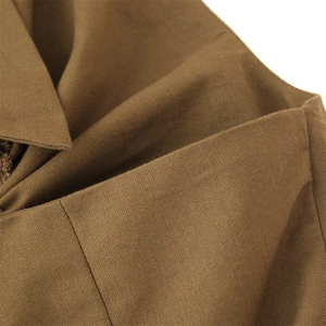 Close-up of brown linen blend fabric showing weave texture and neat neckline stitching