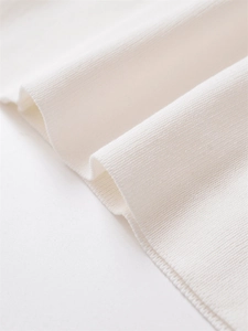 Macro shot showing high-quality white knitted fabric texture with soft ribbed details