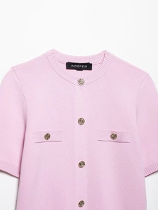 Gros plan du cardigan en tricot rose avec boutons dorés en relief et col rond élégant