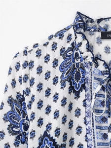 Detail of ruffled stand-up collar and tie string on paisley print bohemian mini dress