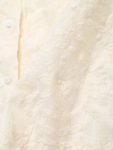 Macro de la broderie florale et des boutons sur tissu en lin et coton crème