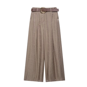 Close-up of champagne satin wide-leg pants with brown belt and wavy gold buckle