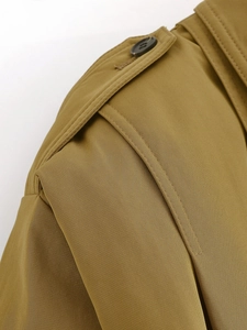Detailed close-up of khaki pilot jacket shoulder epaulette with twill fabric texture