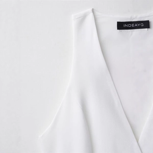 Minimalist white sleeveless V-neck mini dress with elegant INDEAYG brand neck label