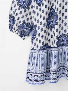 Detailed close-up of blue floral print fabric with cotton linen texture and ruffled hem