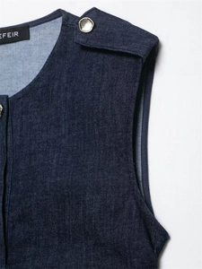 Detail eines dunkelblauen Jeanskleides mit Schulterklappen und silbernen Sechskantknöpfen