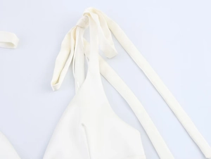 Detail shot of white halter top with long ribbon straps made of smooth elastic fabric