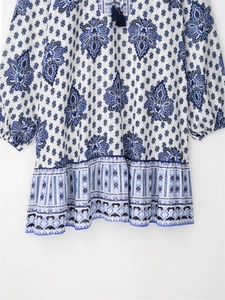Close-up of bohemian floral print with tassel neck ties and pleated ruffle details