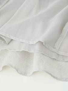 Detail view of double-layer hemline with sequined chiffon and precise stitching finish
