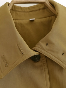 Detailed close-up of premium twill fabric texture and brown button on bomber jacket