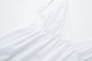 Detail view of white cotton poplin midi dress featuring elegant pleated waist design